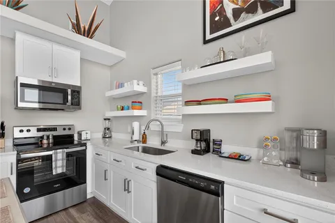 a kitchen with stainless steel appliances granite countertop a sink and a microwave