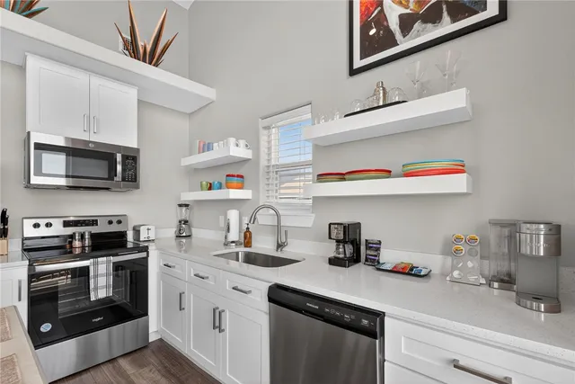 a kitchen with stainless steel appliances granite countertop a sink and a microwave