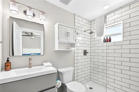 a bathroom with a sink a toilet and shower