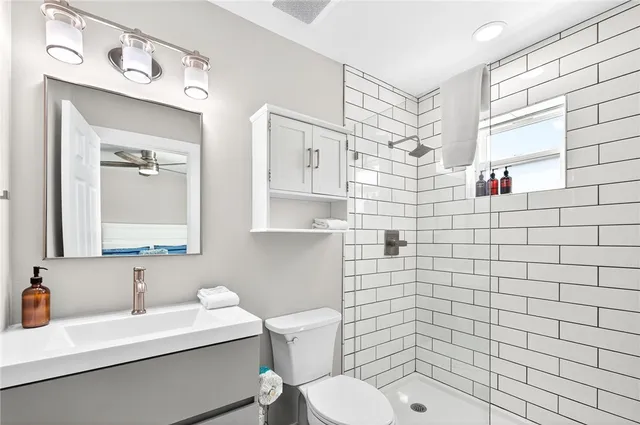 a bathroom with a sink a toilet and shower