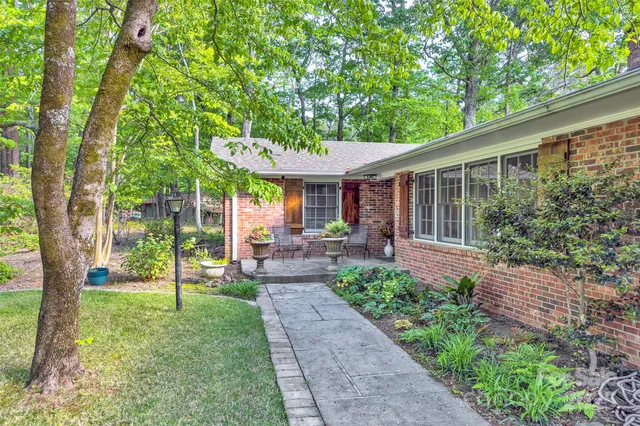 a view of a patio with table and chairs potted plants and large tree