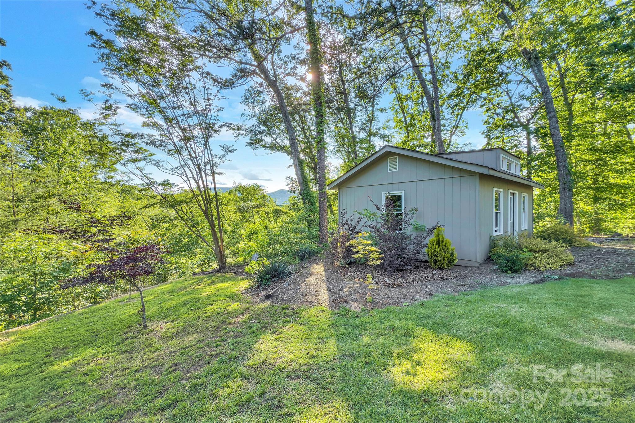 7 Hearthstone Lane Landrum, SC 29356 - Photo 17 of 43 a backyard of a house with table and chairs under an umbrella
