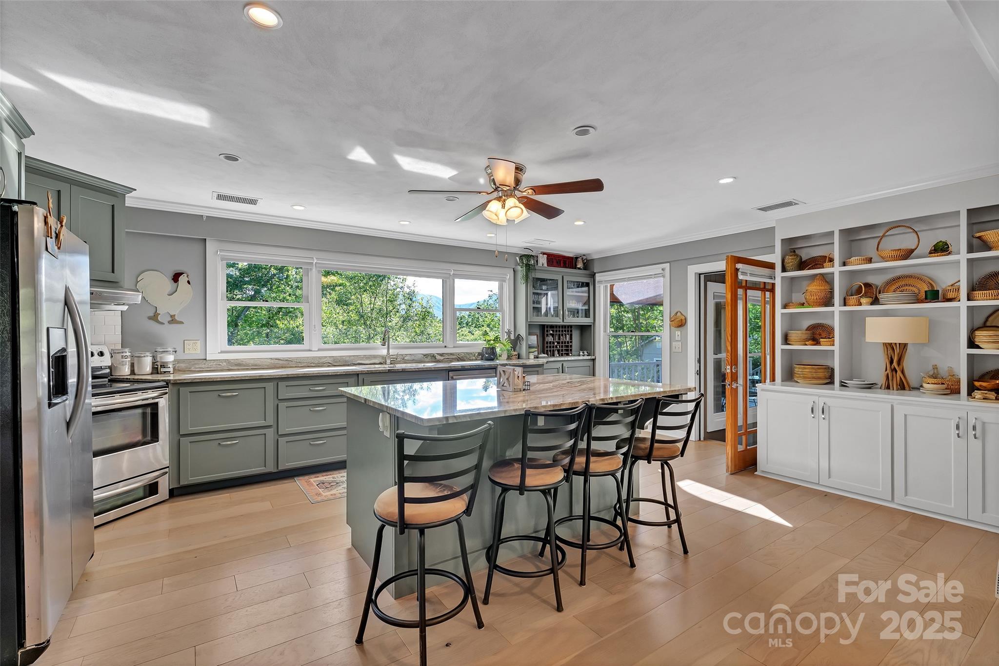 7 Hearthstone Lane Landrum, SC 29356 - Photo 25 of 43 a kitchen with stainless steel appliances granite countertop a stove a refrigerator a microwave a dining table and chairs with wooden floor
