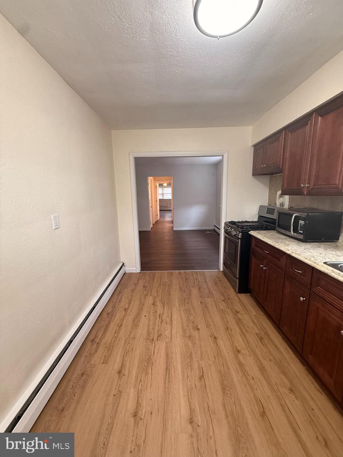 216 Boro Road, Unit A Secane, PA 19018 - Photo 23 of 26 a kitchen with granite countertop a sink cabinets and wooden floor