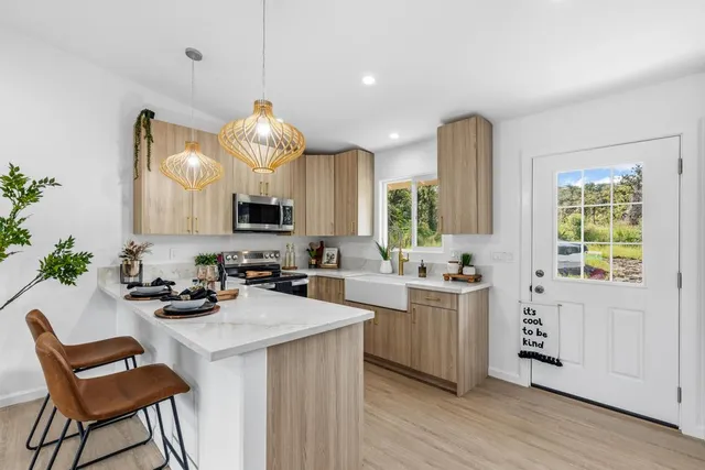 a kitchen with a stove a sink a microwave a dining table and chairs