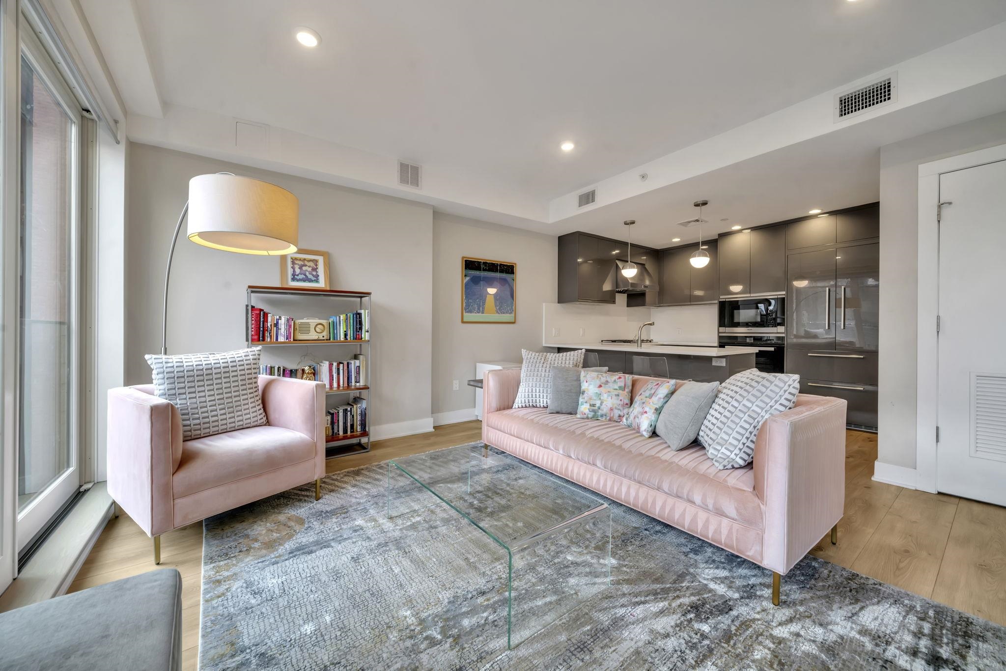 a living room with furniture and a view of kitchen