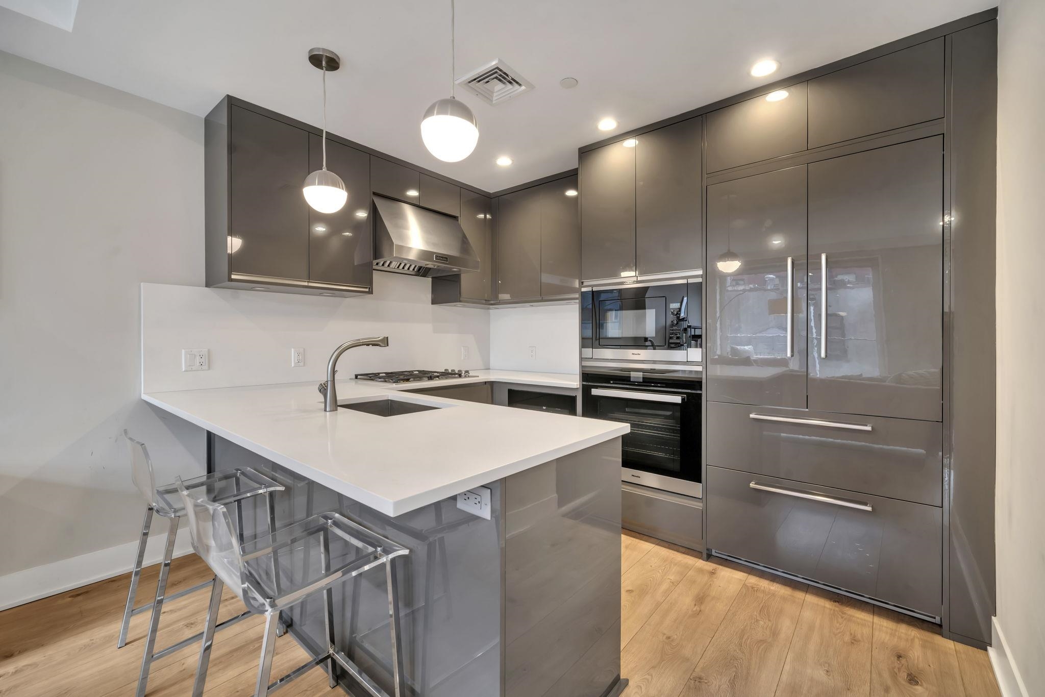 61 14th Street, Unit 3 Hoboken, NJ 07030 - Photo 11 of 31 a kitchen with kitchen island a sink stainless steel appliances and cabinets