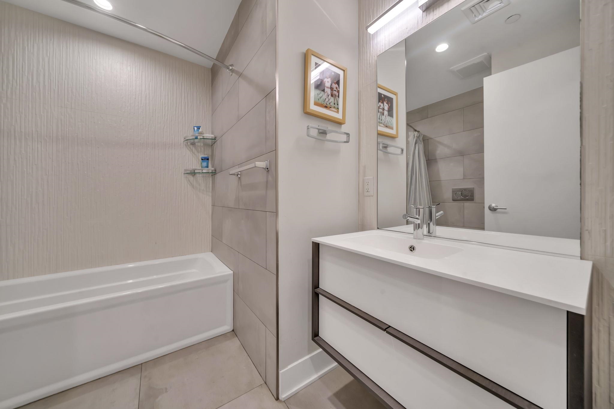 61 14th Street, Unit 3 Hoboken, NJ 07030 - Photo 24 of 31 a bathroom with a tub sink and mirror