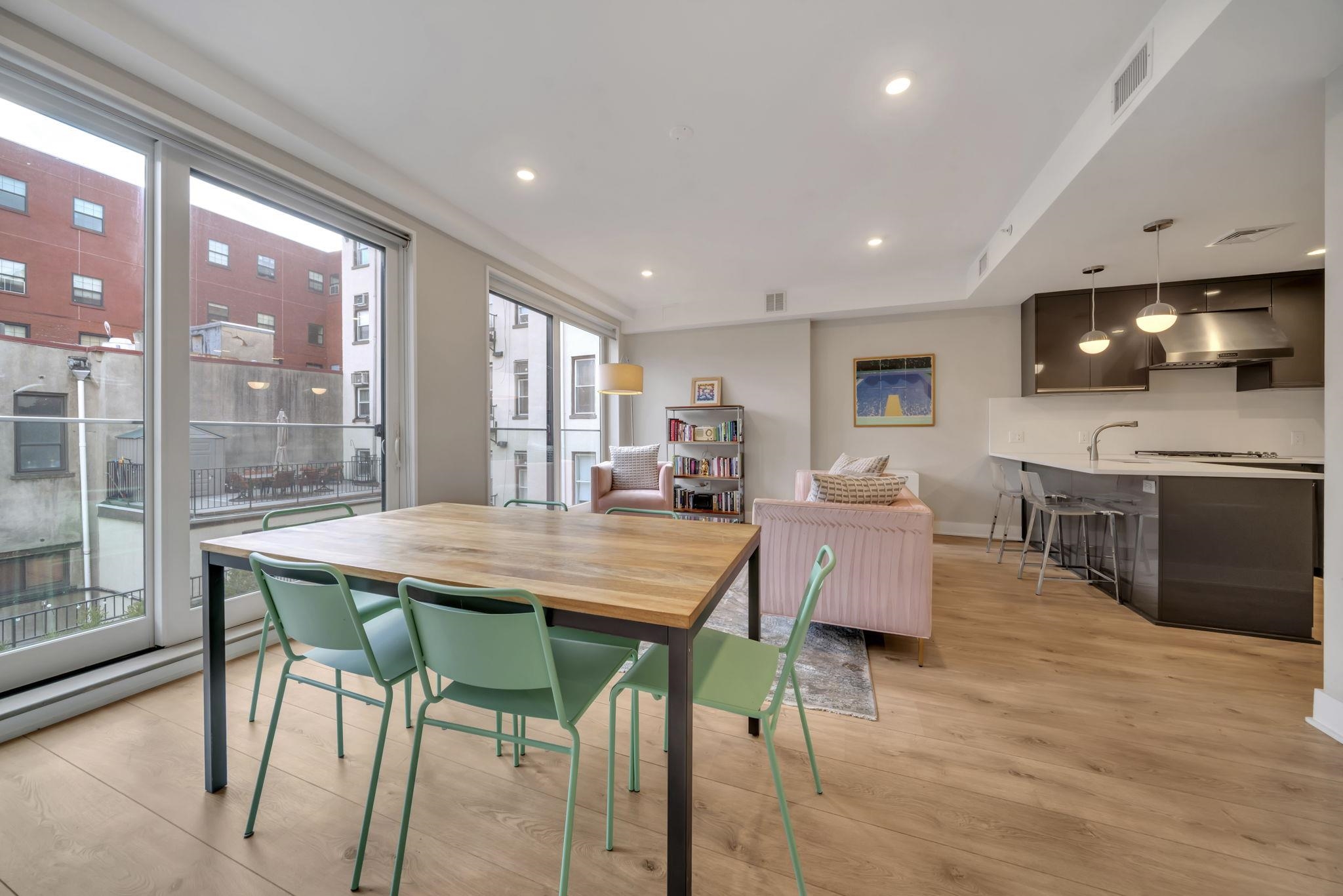 61 14th Street, Unit 3 Hoboken, NJ 07030 - Photo 9 of 31 a dining hall with stainless steel appliances granite countertop a stove a table and chairs with wooden floor