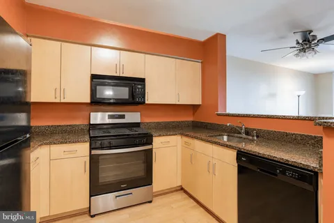 a kitchen with granite countertop a stove sink and microwave