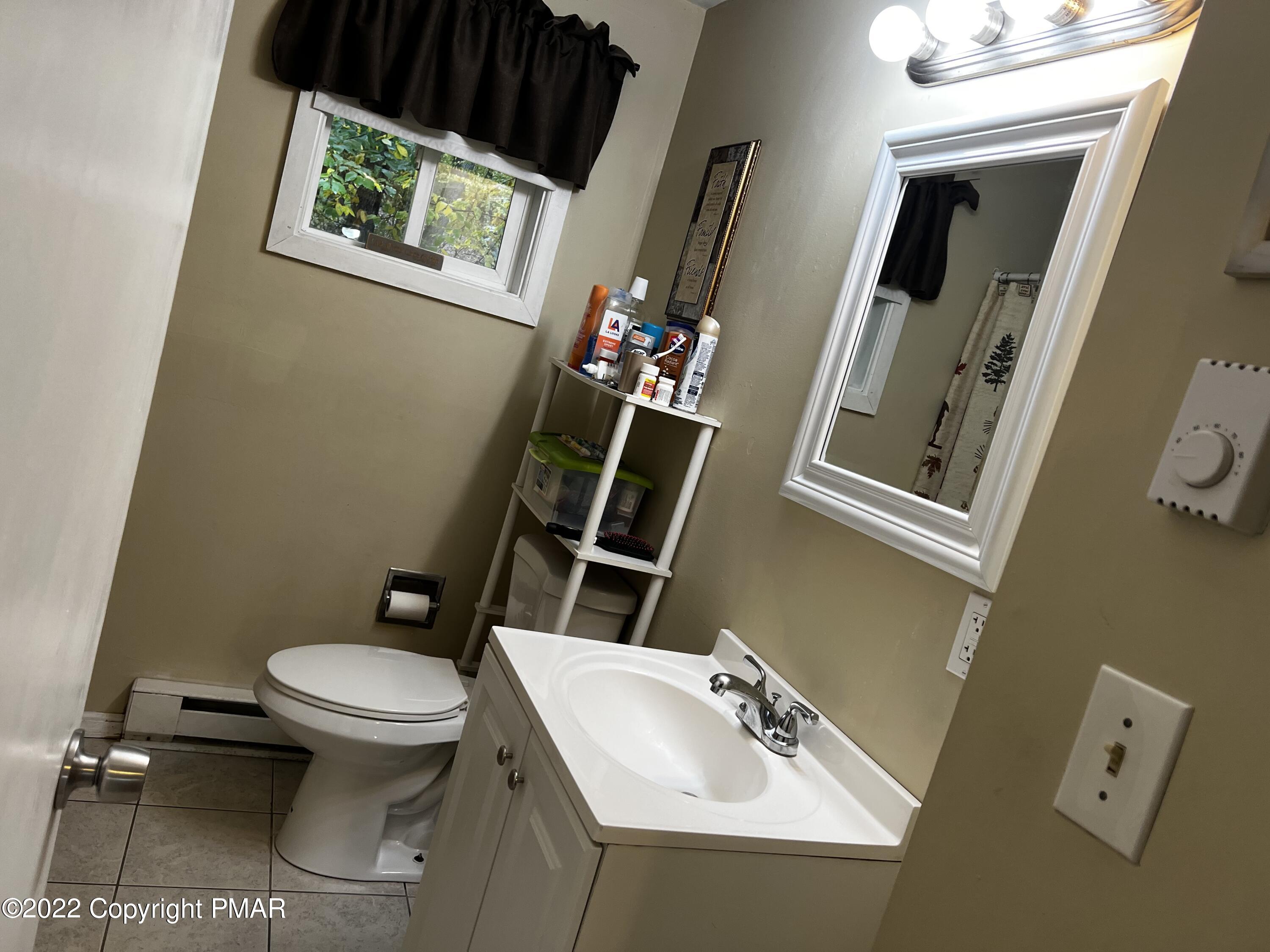 153 Edinburgh Road Bushkill, PA 18324 - Photo 11 of 24 a bathroom with a sink mirror and toilet
