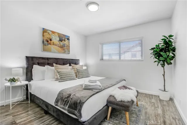 a bedroom with bed and a potted plant