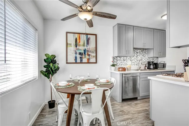 a kitchen with stainless steel appliances a table and chairs in it