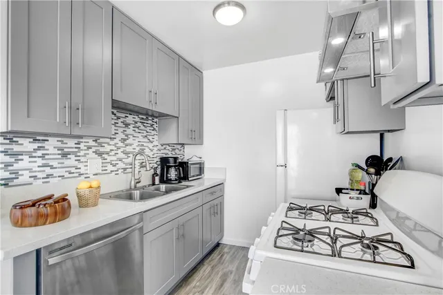 a kitchen with stainless steel appliances a sink a stove and cabinets