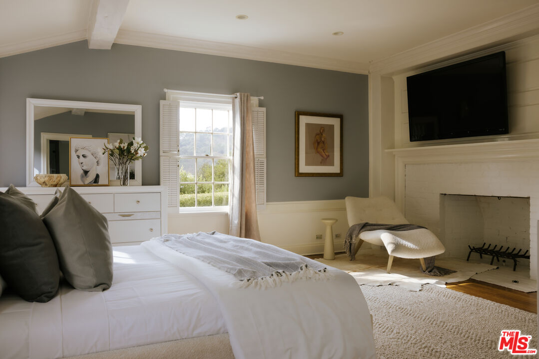 11630 Bellagio Road Los Angeles, CA 90049 - Photo 9 of 18 a bedroom with a bed and a flat screen tv
