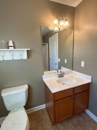 a bathroom with a toilet sink and mirror
