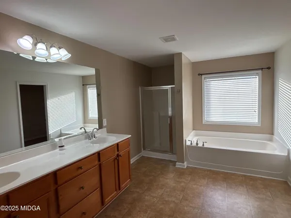a spacious bathroom with double vanity and a mirror