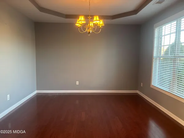 an empty room with wooden floor and windows in walls