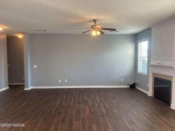a view of empty room with wooden floor and fireplace