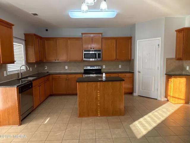 a kitchen with stainless steel appliances granite countertop a stove a sink dishwasher and a refrigerator