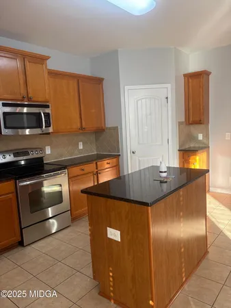 a kitchen with stainless steel appliances granite countertop a sink a stove and a refrigerator