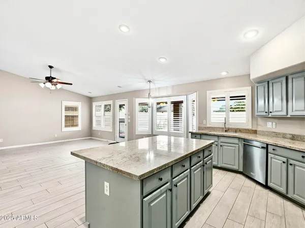 a kitchen with granite countertop center island wooden floor and stainless steel appliances