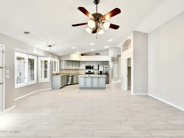 a view of a kitchen with kitchen island a large window appliances and a cabinets