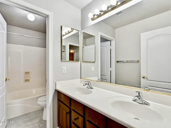 a bathroom with a tub a sink and mirror
