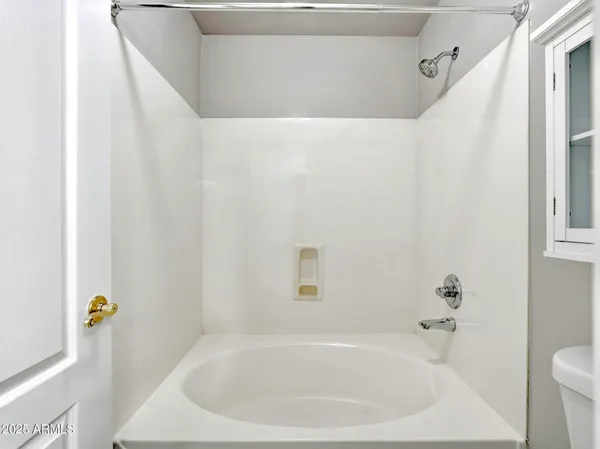 a white bath tub sitting next to a white sink and toilet