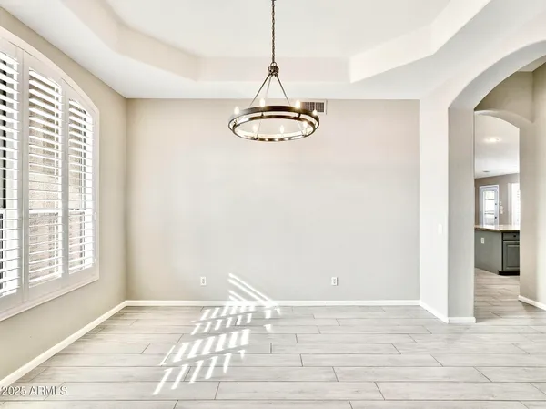 a view of a hallway with wooden floor and chandelier