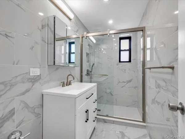 a bathroom with a shower sink and mirror