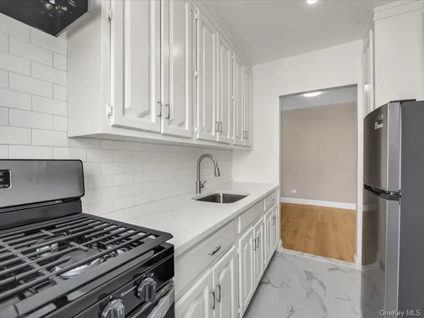 a kitchen with granite countertop a sink stove and refrigerator