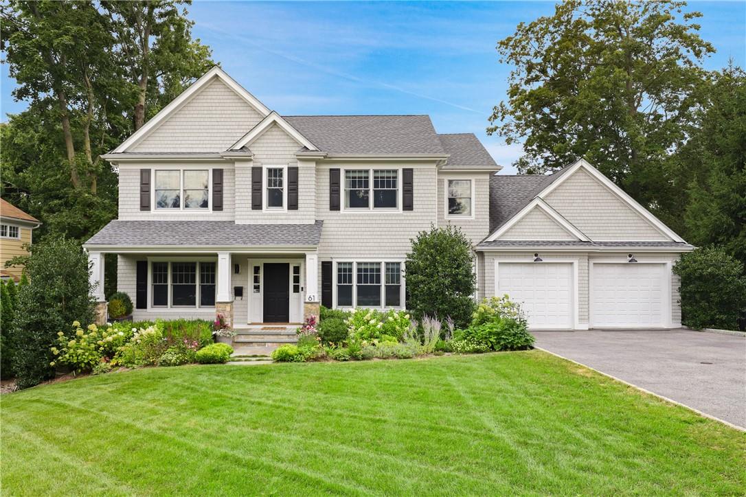 a front view of a house with a yard and trees