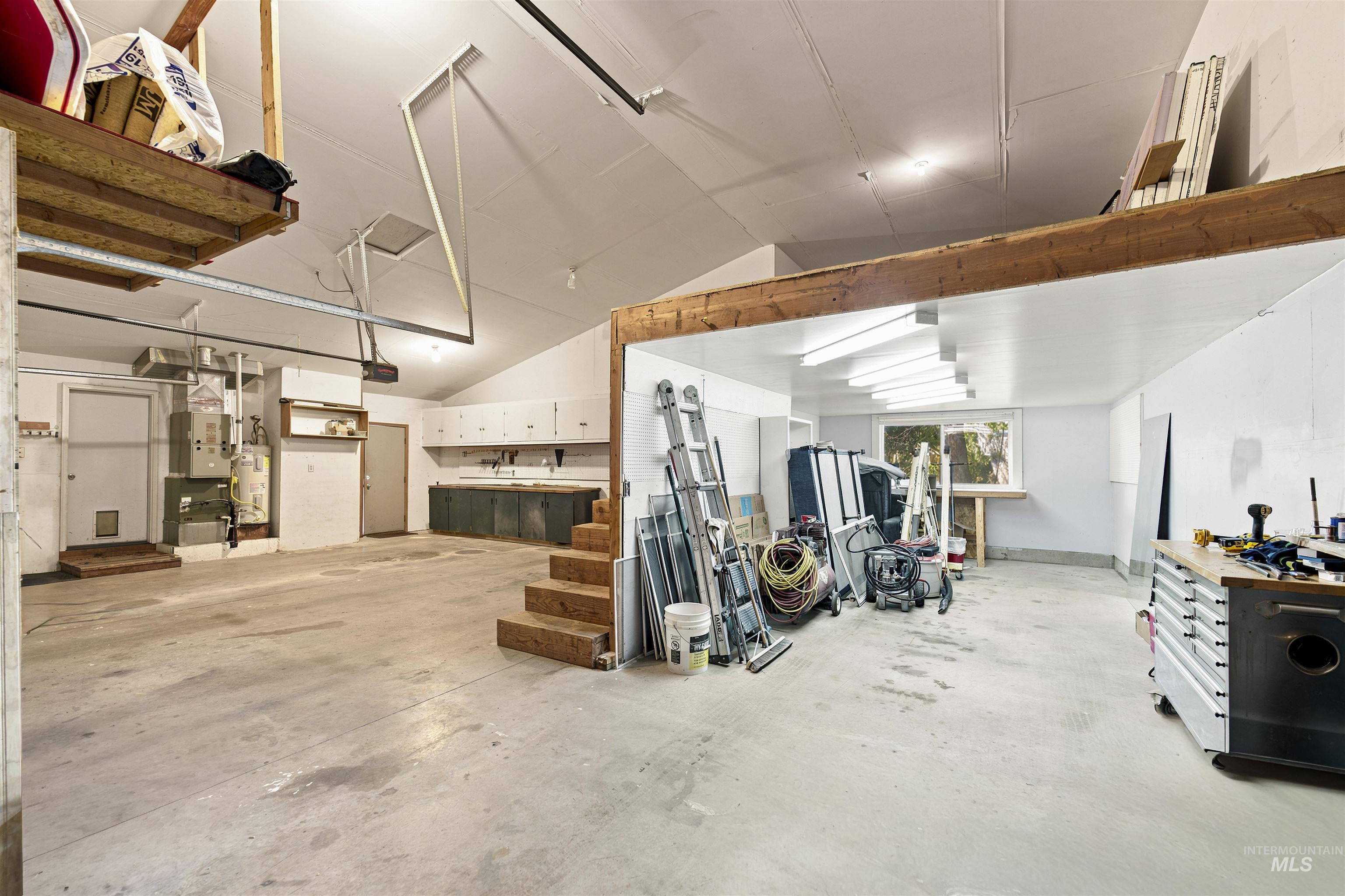 24864 Coventry Drive Caldwell, ID 83607 - Photo 47 of 49 Spacious garage featuring a concrete floor, vaulted ceilings, and extensive built-in cabinetry with a sink