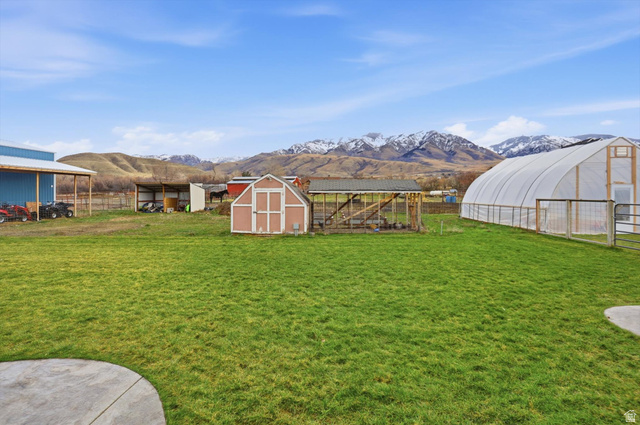 1009 High Creek Road Cove, UT 84320 - Photo 69 of 79 View of yard featuring an outdoor structure, a mountain view, and an exterior structure, shed and greenhouse