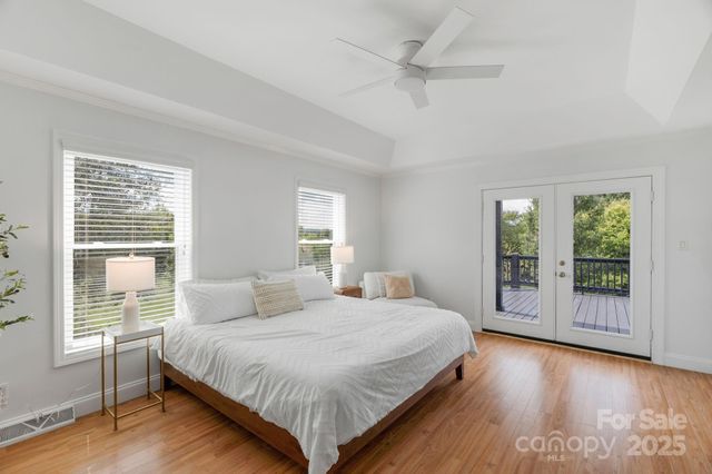 a bedroom with a large bed and wooden floor