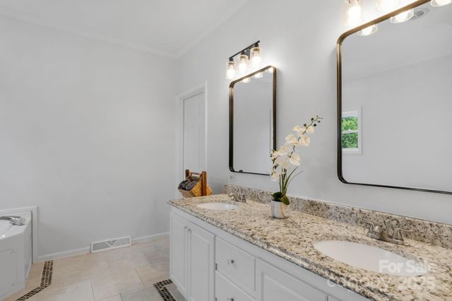 a bathroom with double vanity sink and a mirror