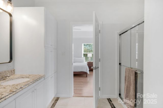 a en suite bathroom with a granite countertop sink and a mirror