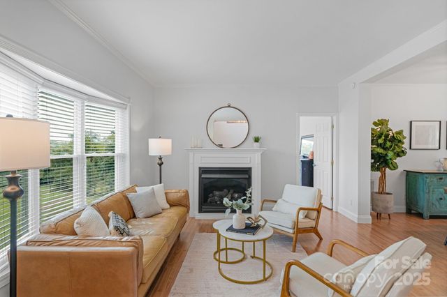 a living room with furniture a fireplace and a floor to ceiling window