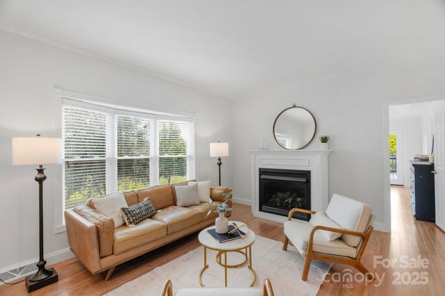 a living room with furniture a fireplace a window and a large window