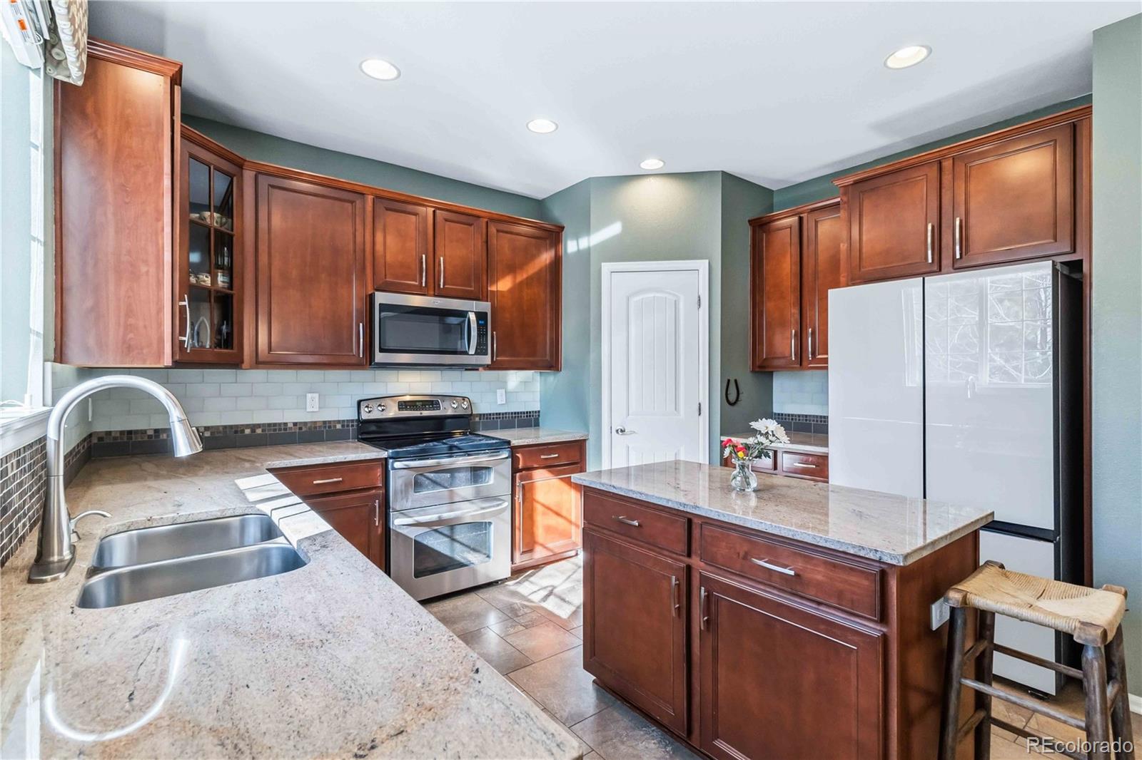 14144 Greenfield Loop Parker, CO 80134 - Photo 14 of 50 a kitchen with stainless steel appliances granite countertop wooden cabinets a stove top oven a sink and dishwasher