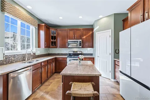 a kitchen with stainless steel appliances granite countertop a stove microwave and sink