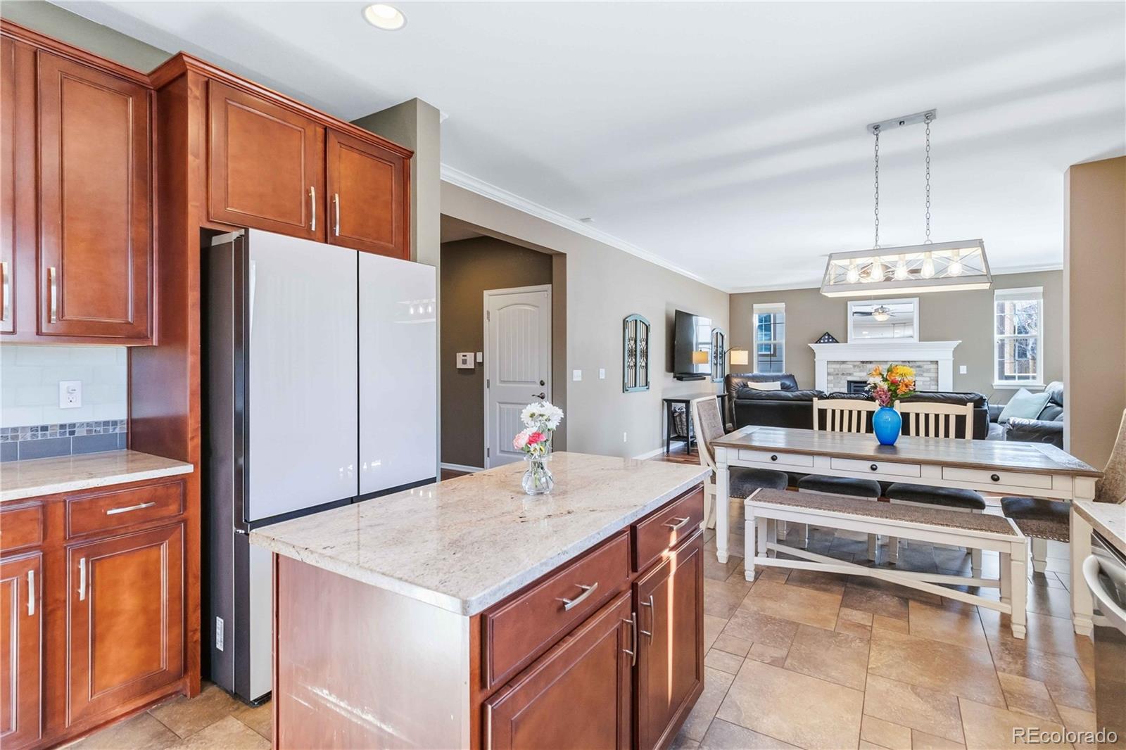 14144 Greenfield Loop Parker, CO 80134 - Photo 17 of 50 a kitchen with stainless steel appliances a stove a refrigerator a sink dishwasher and white cabinets with wooden floor