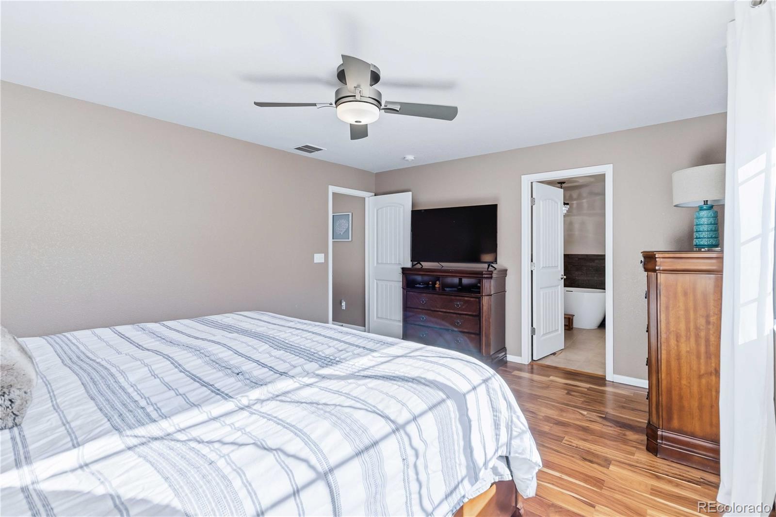 14144 Greenfield Loop Parker, CO 80134 - Photo 21 of 50 a bedroom with a bed and a flat screen tv