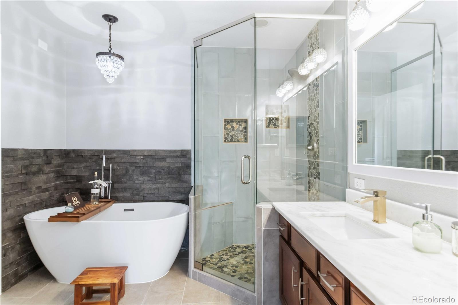 14144 Greenfield Loop Parker, CO 80134 - Photo 23 of 50 a bathroom with a granite countertop sink a mirror and shower