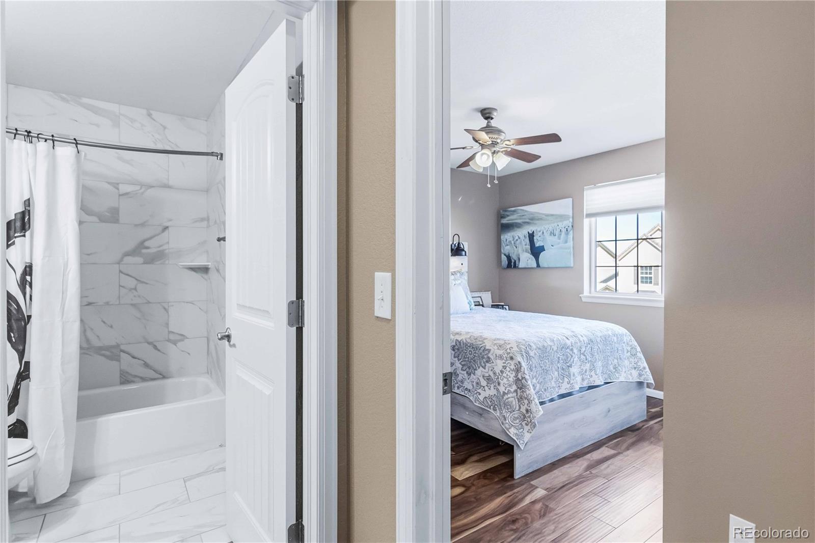 14144 Greenfield Loop Parker, CO 80134 - Photo 28 of 50 a bedroom with a bed and a chandelier