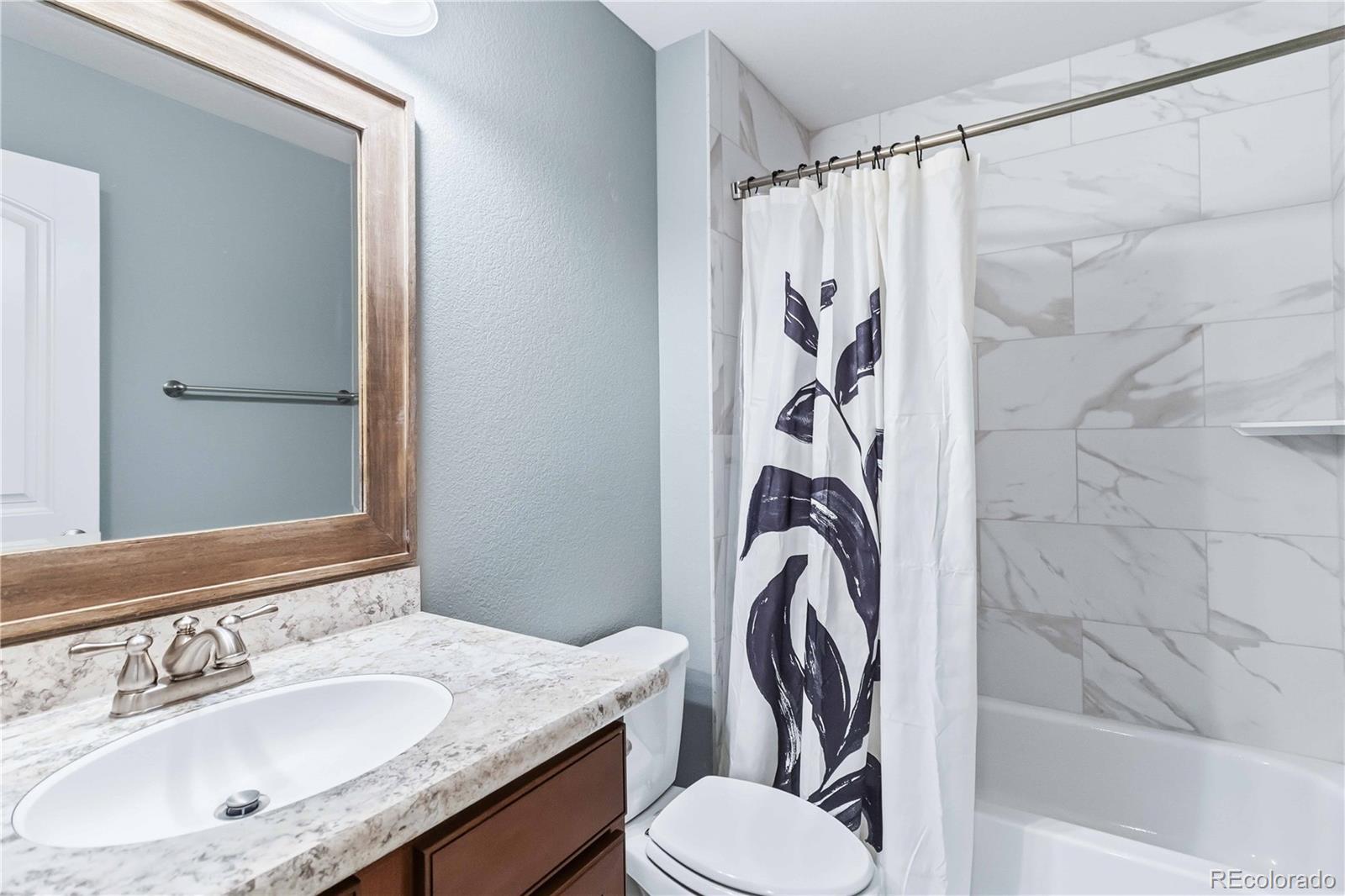 14144 Greenfield Loop Parker, CO 80134 - Photo 29 of 50 a bathroom with a sink a toilet and shower