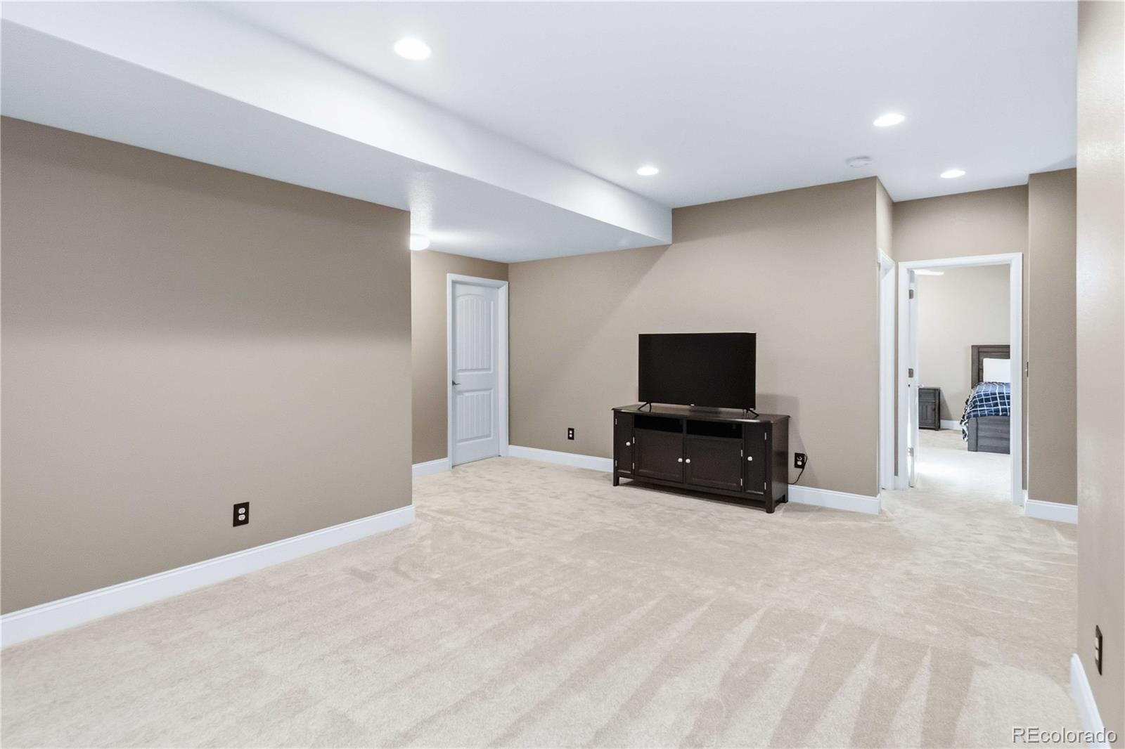 14144 Greenfield Loop Parker, CO 80134 - Photo 33 of 50 a living room with furniture and a flat screen tv