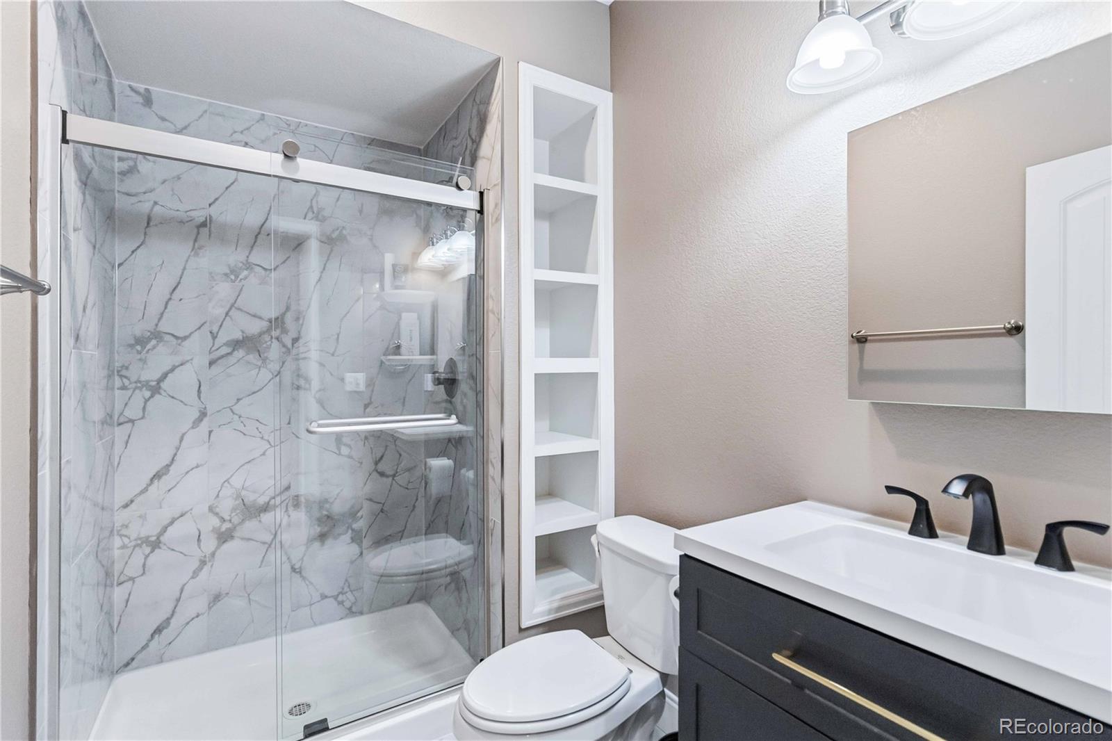 14144 Greenfield Loop Parker, CO 80134 - Photo 34 of 50 a bathroom with a sink toilet vanity and shower