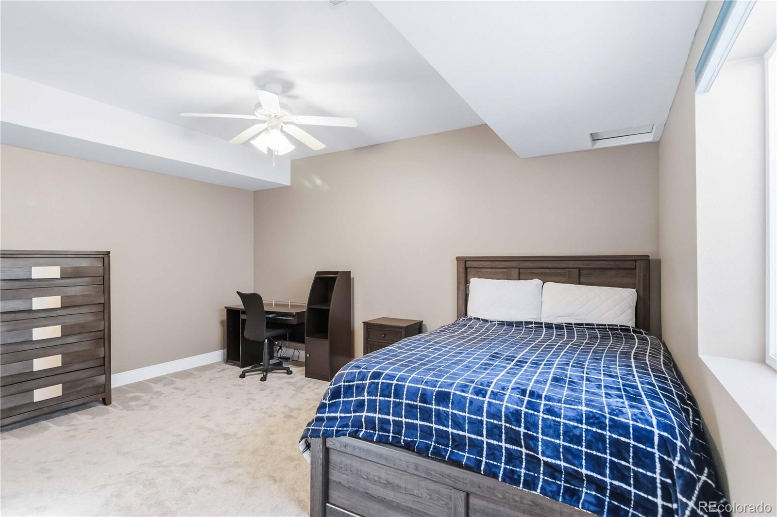 14144 Greenfield Loop Parker, CO 80134 - Photo 35 of 50 a bedroom with a bed and a chair